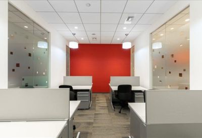 Modern office booths with a vibrant red accent wall and frosted glass partitions.