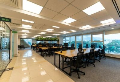 Modern coworking area with large windows, natural light, and polished tile flooring.