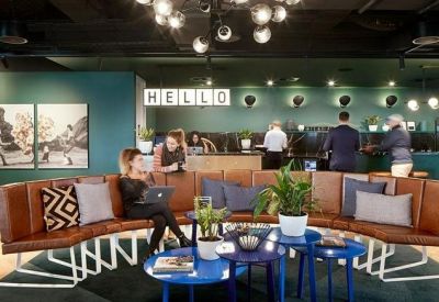 Reception area with a Hello sign, curved leather seating, and a view of the bar.