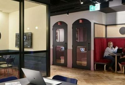 Private meeting booths with red velvet seating and dark framed glass doors.