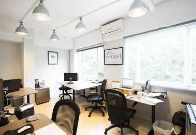 Private office suite with multiple desks, ergonomic chairs, and large windows.