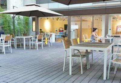 Spacious outdoor patio with multiple tables, chairs, and large sun umbrellas.