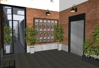 Industrial-style reception lobby with brick walls, potted plants, and sleek elevator doors.
