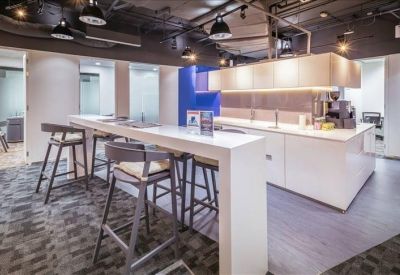 Spacious breakout area with a high white breakfast bar and modern stools.