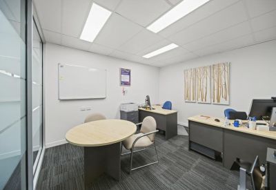 Bright internal office suite with two desks and a small round meeting table.
