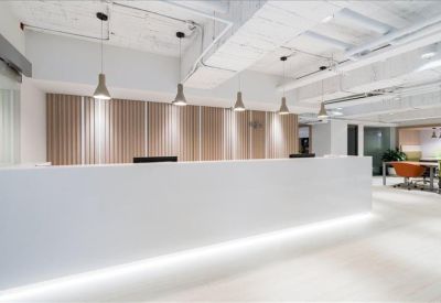 Clean, white reception desk area with warm pendant lighting.