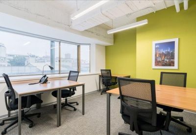 Bright corner office with lime green feature wall and large windows.