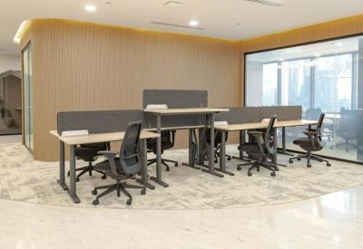Modern coworking area with adjustable height desks and floor-to-ceiling windows.