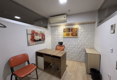 Private office with a textured feature wall and orange chairs.