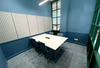Contemporary meeting room with sage green walls and a white conference table.