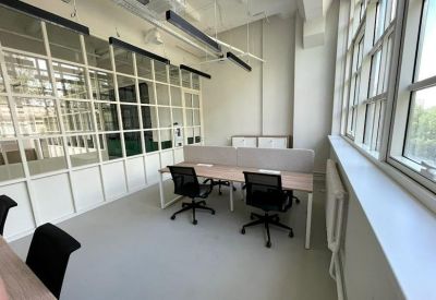 Minimalist workspace featuring black ergonomic chairs and white desks.