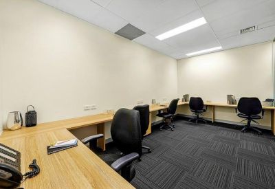 Quiet internal office space with multiple workstations along the walls and black chairs.