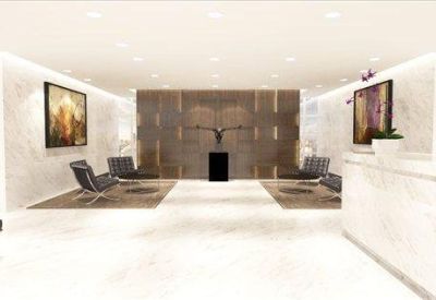 Bright white marble reception area with a long desk and comfortable seating areas.