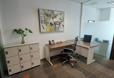 Private office featuring a wooden desk, ergonomic chair, and storage lockers.