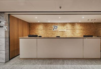 Minimalist white reception desk set against a warm textured wooden feature wall.
