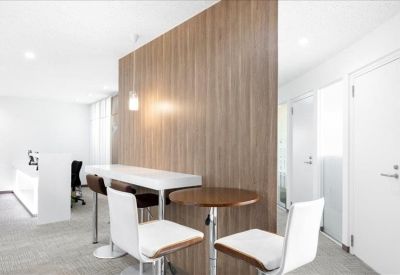 Communal break area with a wooden feature wall, high-top counter, and cafe seating.