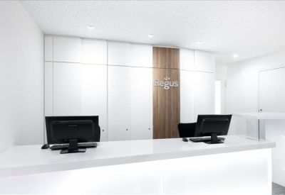 Clean, modern reception area with a white front desk and wood-paneled feature wall.
