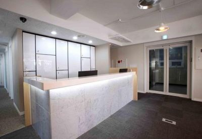 Modern reception desk with integrated lighting and a decorative paneled back wall.