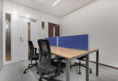 Shared workspace with two black mesh chairs and a blue privacy screen.