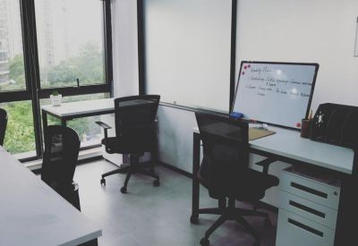 Bright corner office suite with two workstations and a whiteboard.