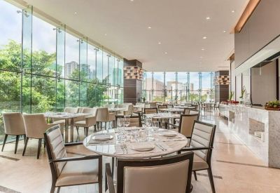 Bright dining area with marble tables and floor-to-ceiling windows.
