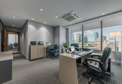 Modern corner office with executive desk and panoramic city views.