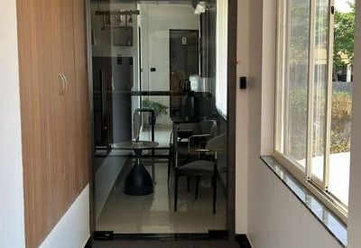 A narrow hallway leading to a glass-walled office space with wooden wall accents.