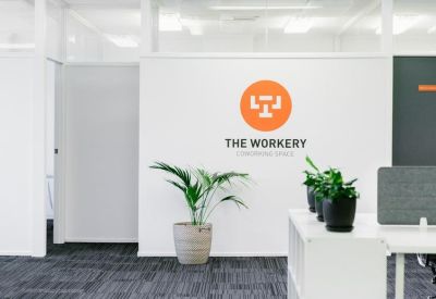 Branded office wall for The Workery Coworking Space with a large orange logo.
