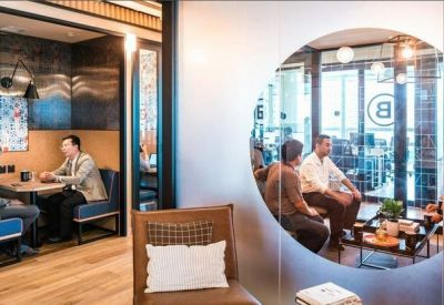 Meeting area with private booths and a circular glass window looking into a lounge.