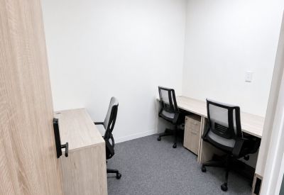 Private three-person office suite with light wood desks and ergonomic mesh chairs.
