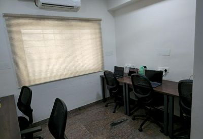 Four-person office suite with workstations and a window.