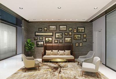 Reception lounge with a leather sofa, decorative gallery wall, and a large patterned area rug.
