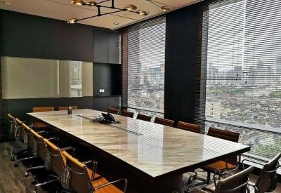 Professional boardroom featuring a long marble table, leather chairs, and floor-to-ceiling windows.