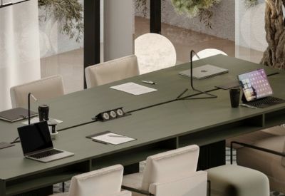 Meeting room with a long table, chairs, and laptops.