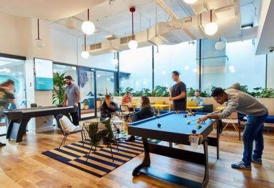Spacious communal area featuring a pool table, air hockey, and large windows with natural light.