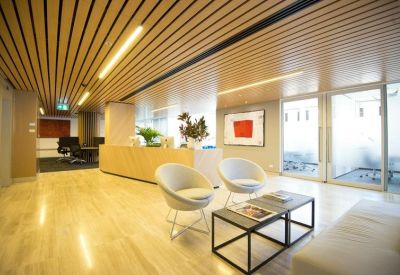 Reception area with wood panel ceiling and modern seating.