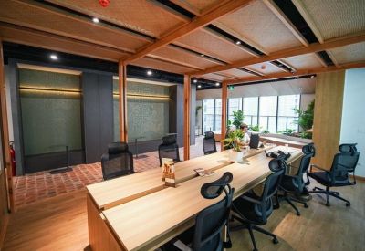 Spacious communal work area featuring high wood-beamed ceilings and natural light.