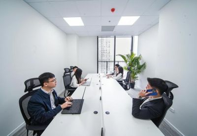 Shared office suite with white desks and a view of the city.