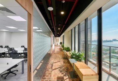 Sunny corridor workspace with indoor plants and a window-side seating bench.