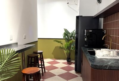 Communal breakroom with a checkered floor, stools, and coffee preparation area.