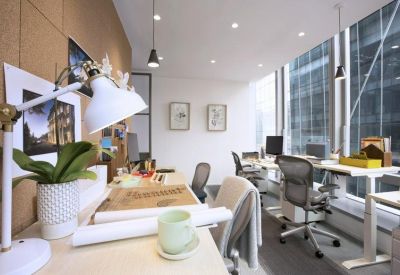 Bright corner office workstations with ergonomic chairs and large windows.