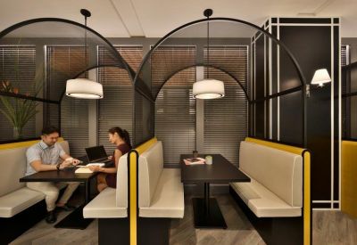 Private meeting booths with black mesh arched covers and comfortable bench seating.