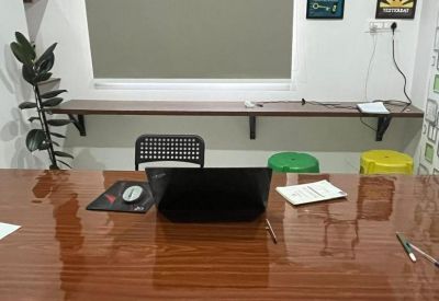 Workspace with a large wooden table and wall-mounted desk at 7, Basapura Main Road, SMS Complex.