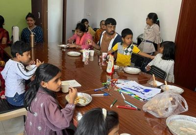 Communal dining or activity area with people gathered around a long, polished wooden table.