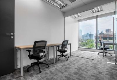 Two-person private office suite with grey patterned carpet and a view of urban greenery.
