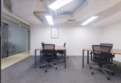 Small internal office suite with two wooden desks and black ergonomic chairs.