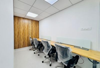 Private office with four workstations and wooden panel wall.
