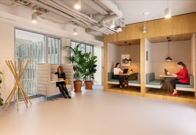 Private work booths built into a wooden wall next to large windows.