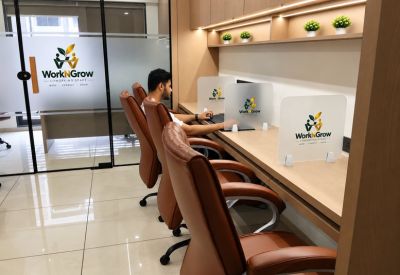 Office area with a person seated at communal desks.