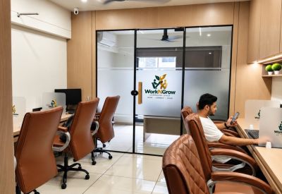 Shared workspace with brown chairs and a glass partition.